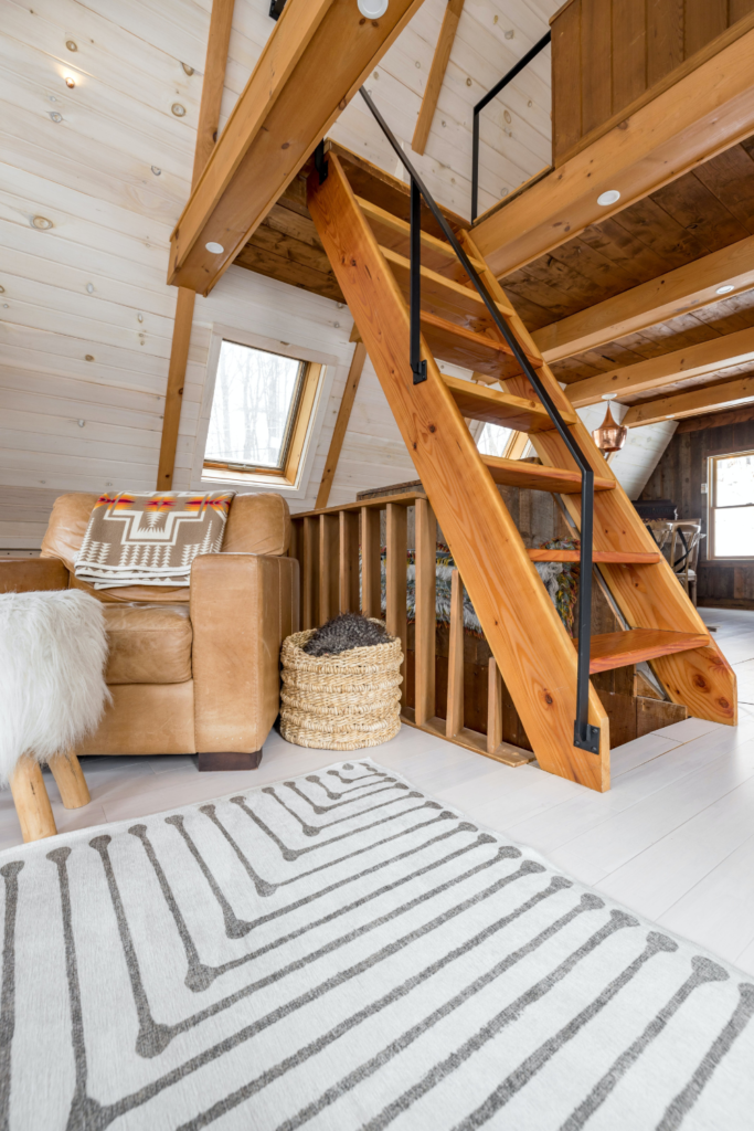 Airbnb luxury A-frame cabin sitting room area with stairs leading to the second story bedroom