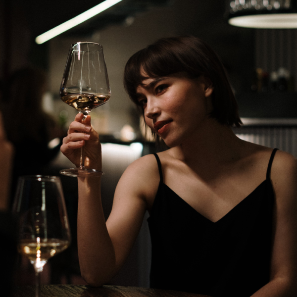 Image of woman with black hair holding wine glass in restaurant