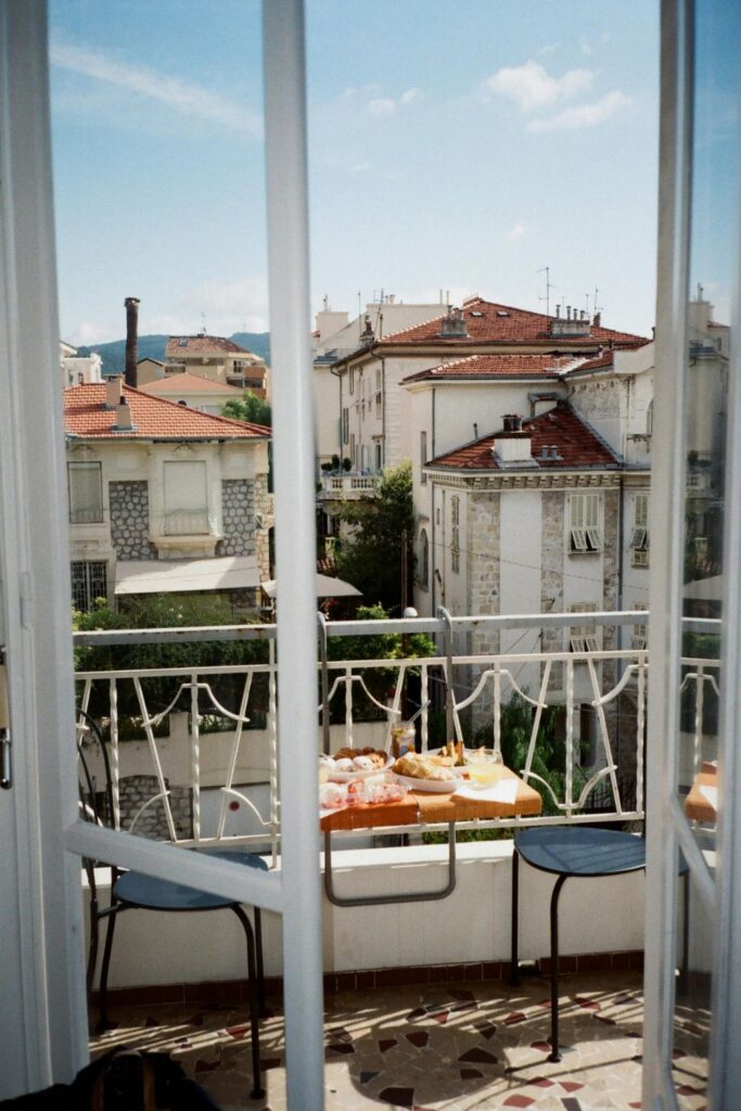 Image of Airbnb open balcony door with rooftop view of a city beyond