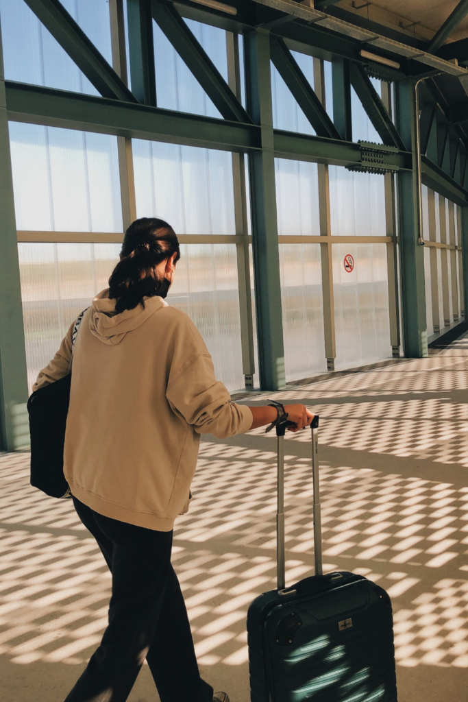 woman in airport with luggage walking through the gates