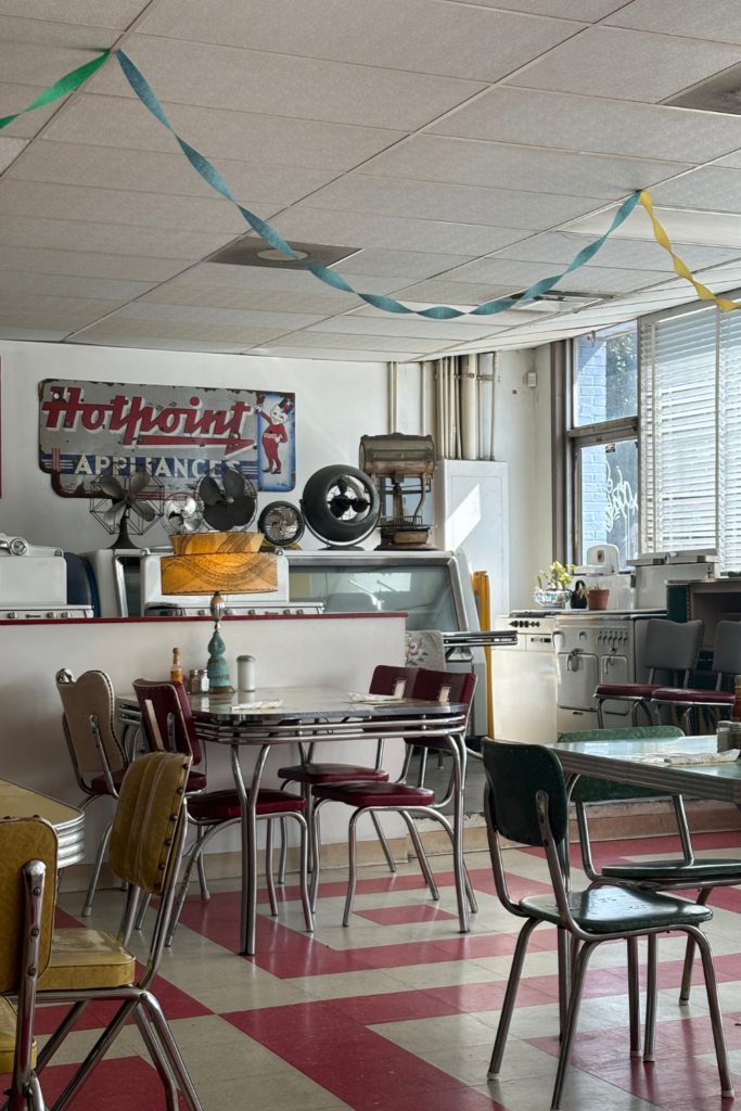 Image of the inside of a 1950's diner in Atlanta Georgia with 50's era furniture and red and white flooring.