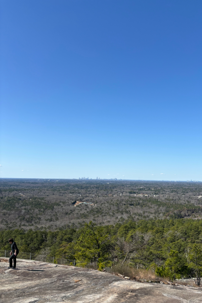 first person point of view from the top of Stone Mountain, overlooking the forests and Atlanta in the distance.