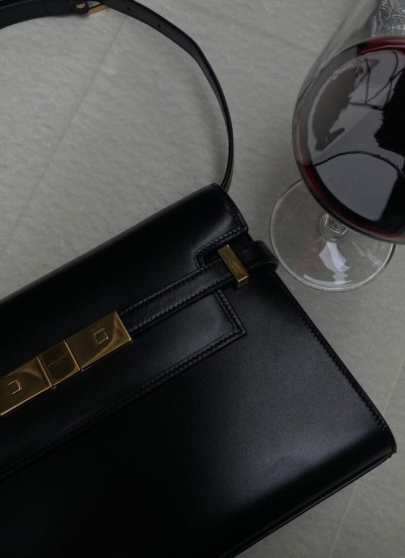 Image of black purse and glass of red wine on a white table during a date in atlanta