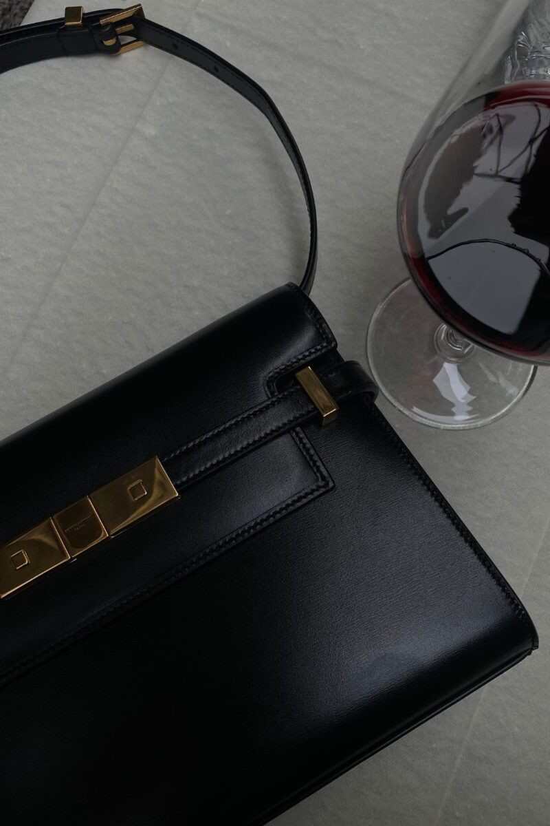 Image of black purse and glass of red wine on a white table during a date in atlanta