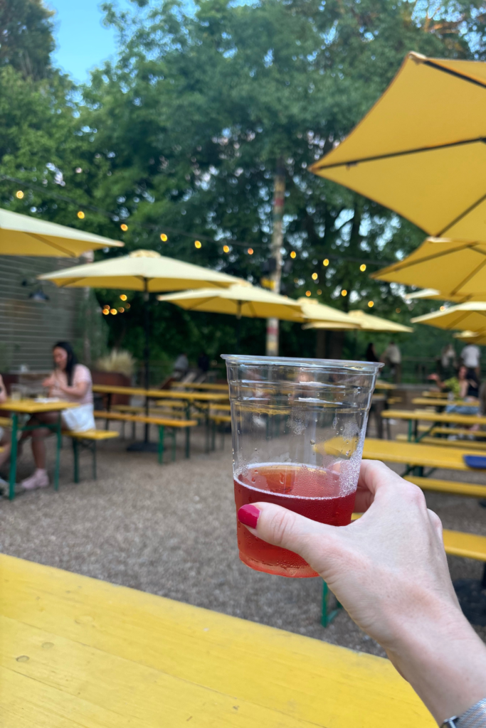 Image of a plastic cup holding a drink at the yellow outdoor tables at Ladybird Grove and Mess Hall in Old Fourth Ward Atlanta Georgia, one of the best restaurant near beltline atlanta