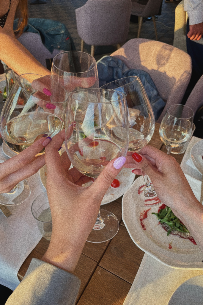 image of white wine glasses in hand during a tour of Helen Georgia wineries and vineyards