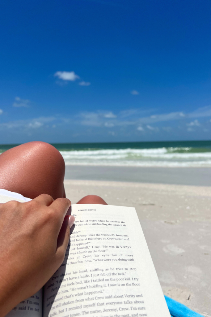 image of a woman reading a book on a beach road trip from Charleston SC