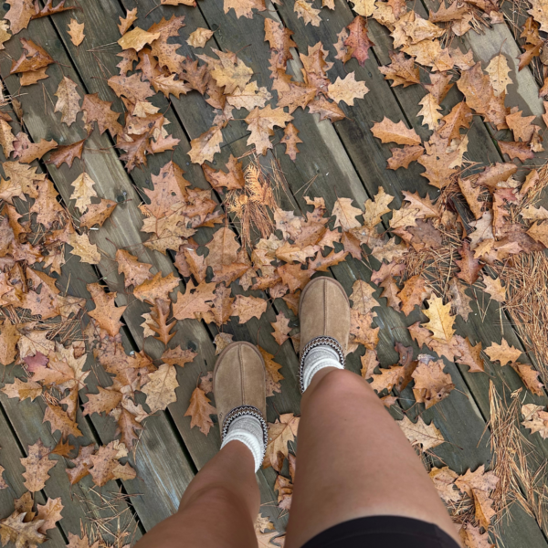 First person point of view of woman looking down at feet, standing in fall leaves during November in Atlanta