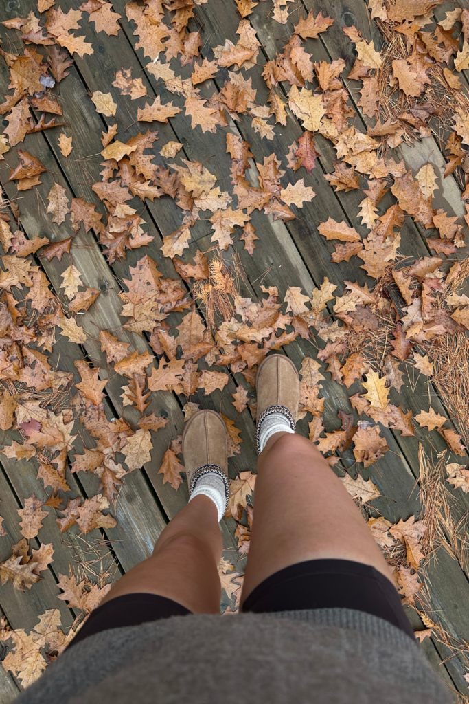 First person point of view of woman looking down at feet, standing in fall leaves during November in Atlanta