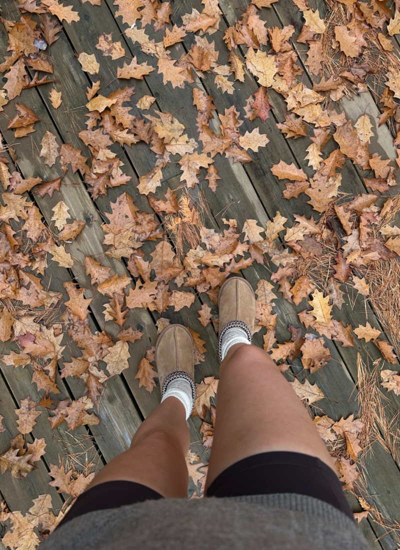 First person point of view of woman looking down at feet, standing in fall leaves during November in Atlanta