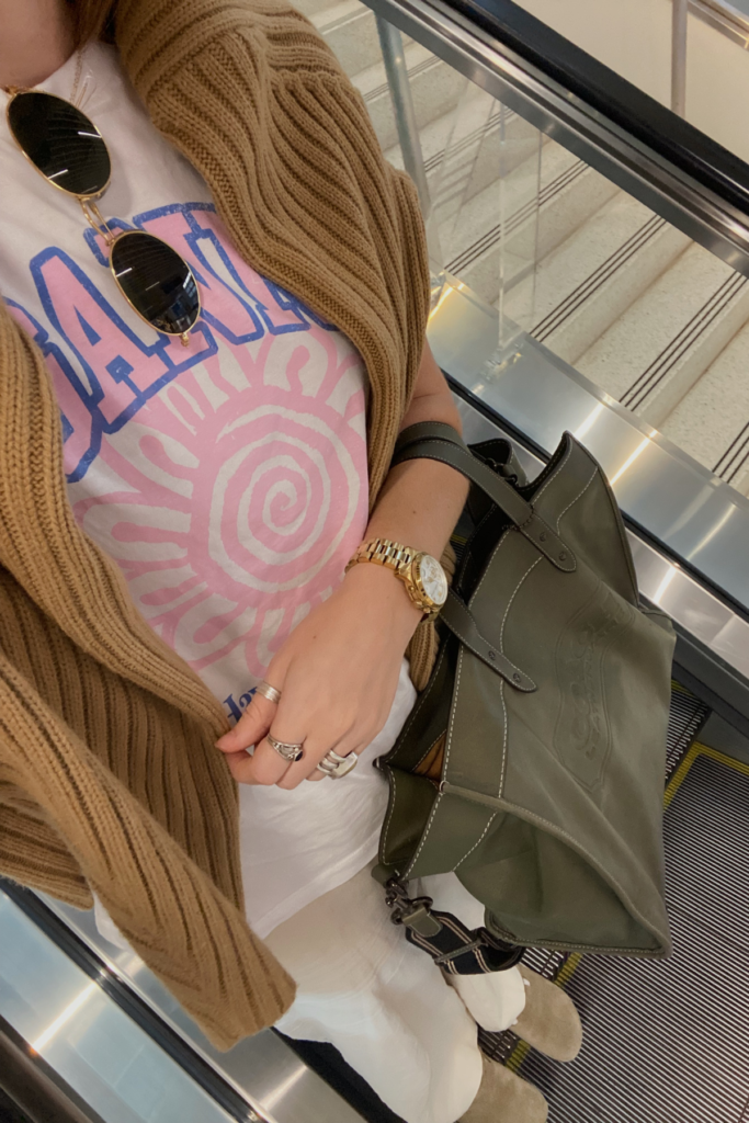 Selfie image of woman holding carry on bag in airport. This is part of the article that answers the question what if my carry on is one inch too big