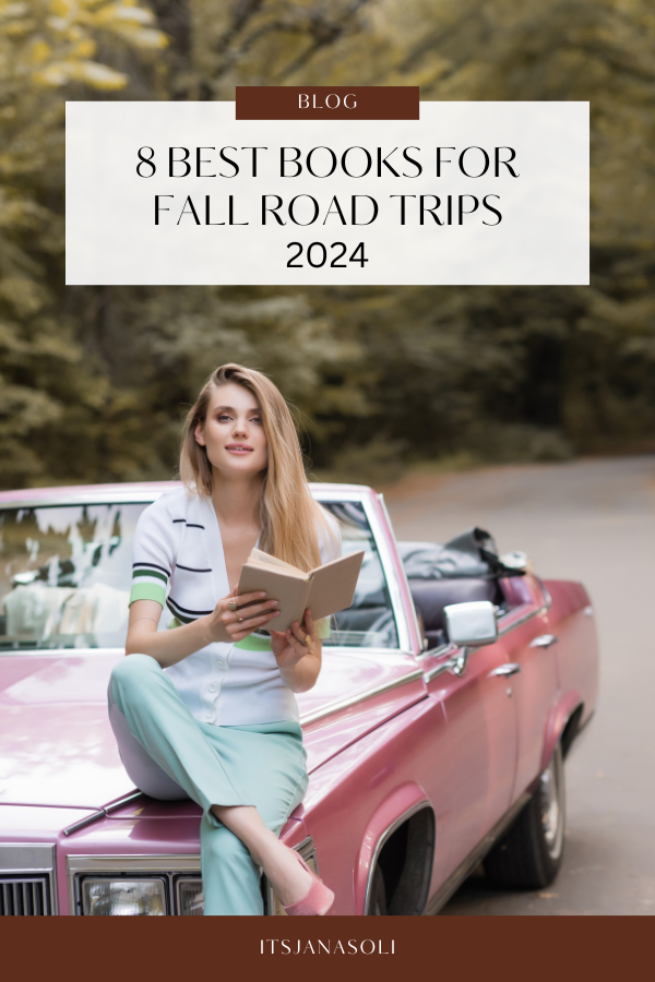 Image of woman sitting on red car hood, crossing legs while reading a book and smiling.