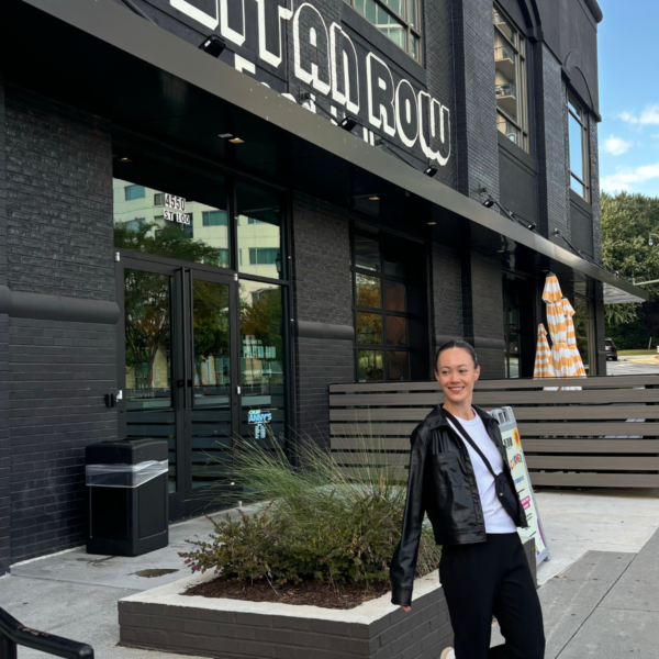 Image of woman wearing leather jacket walking out of food hall in Atlanta Georgia.