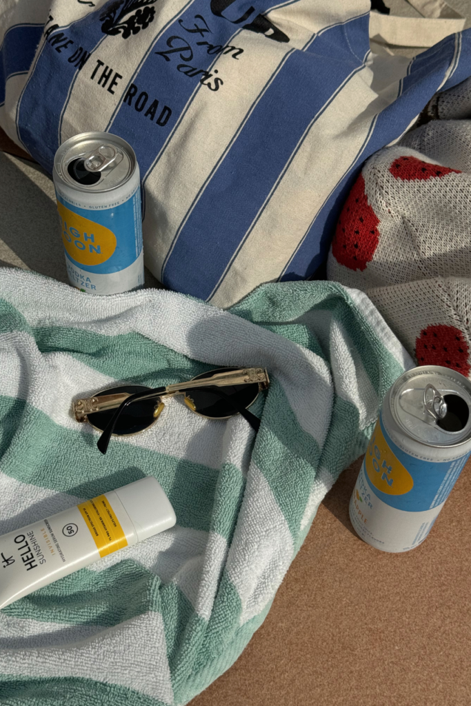 Image of beach towels, sun glasses, and high noon drinks.