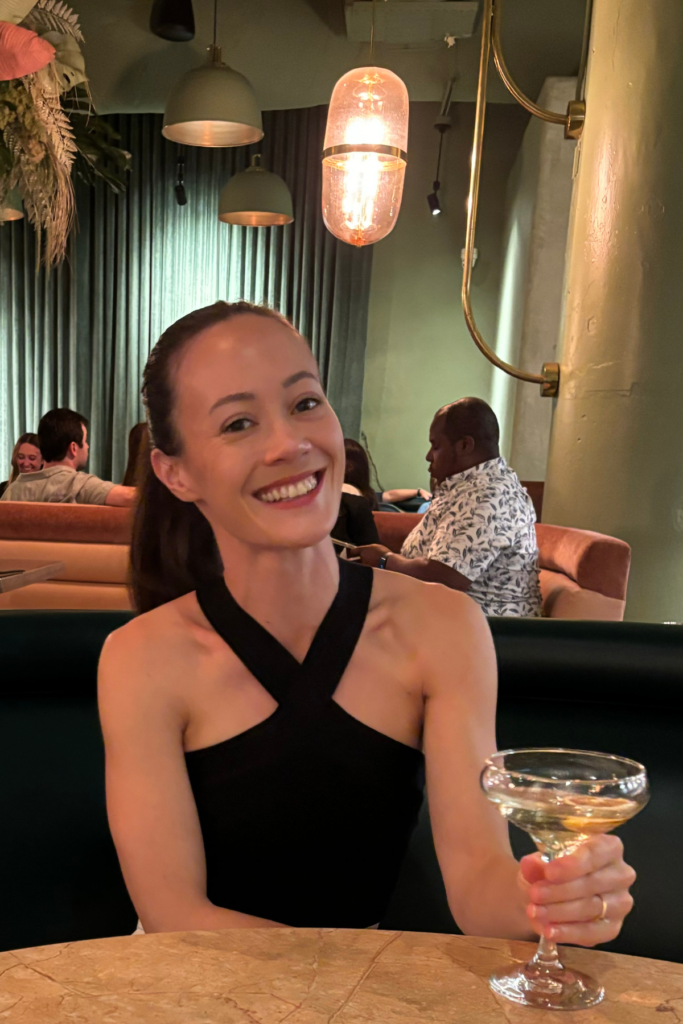 Woman smiling holding a drink at Ponce City Market during food tour in Atlanta in January.